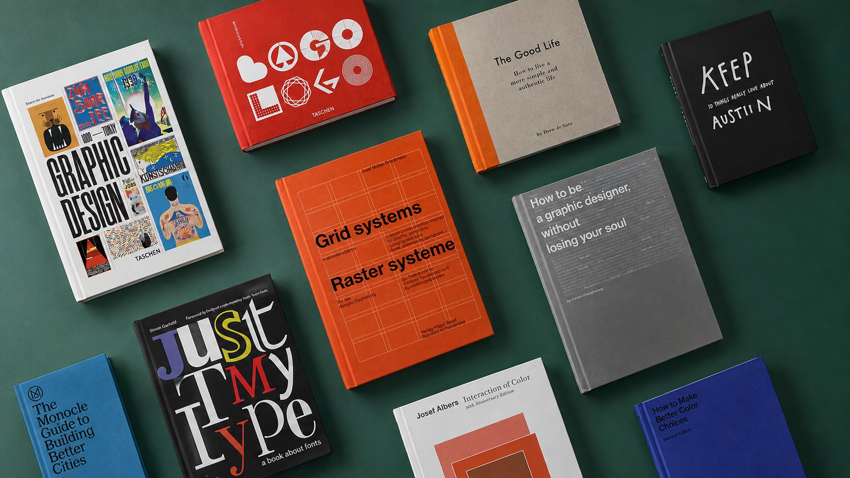 A flat-lay of graphic design books arranged on a dark green surface, including titles on logo design, grid systems, typography, and color theory